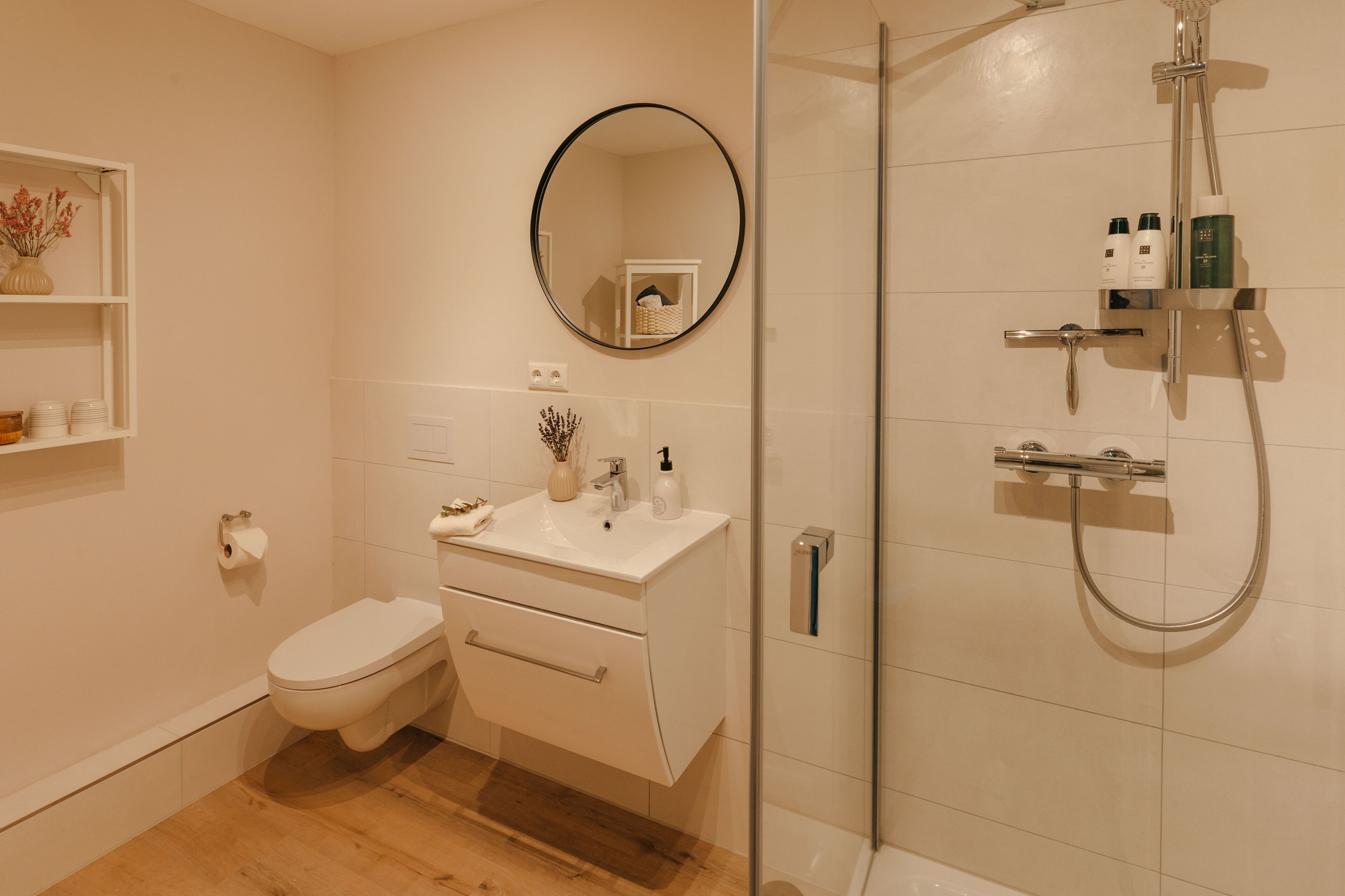 Une salle de bain moderne équipée de toilettes, d’un lavabo et d’une douche.