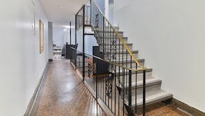 Un couloir avec un escalier menant à l’étage supérieur.