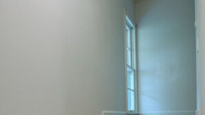 Una escalera con peldaños de madera y paredes blancas.