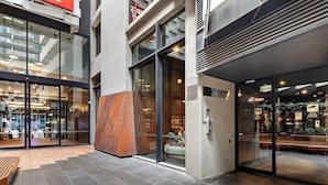 A modern building with large glass windows, a prominent address sign, and a metal facade.