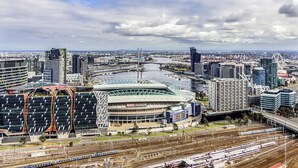 A cityscape with a stadium, modern buildings, and a river.