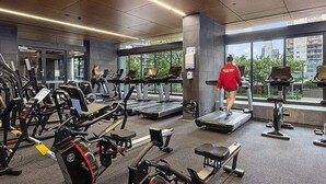 A gym with treadmills, elliptical machines, and weight stations.