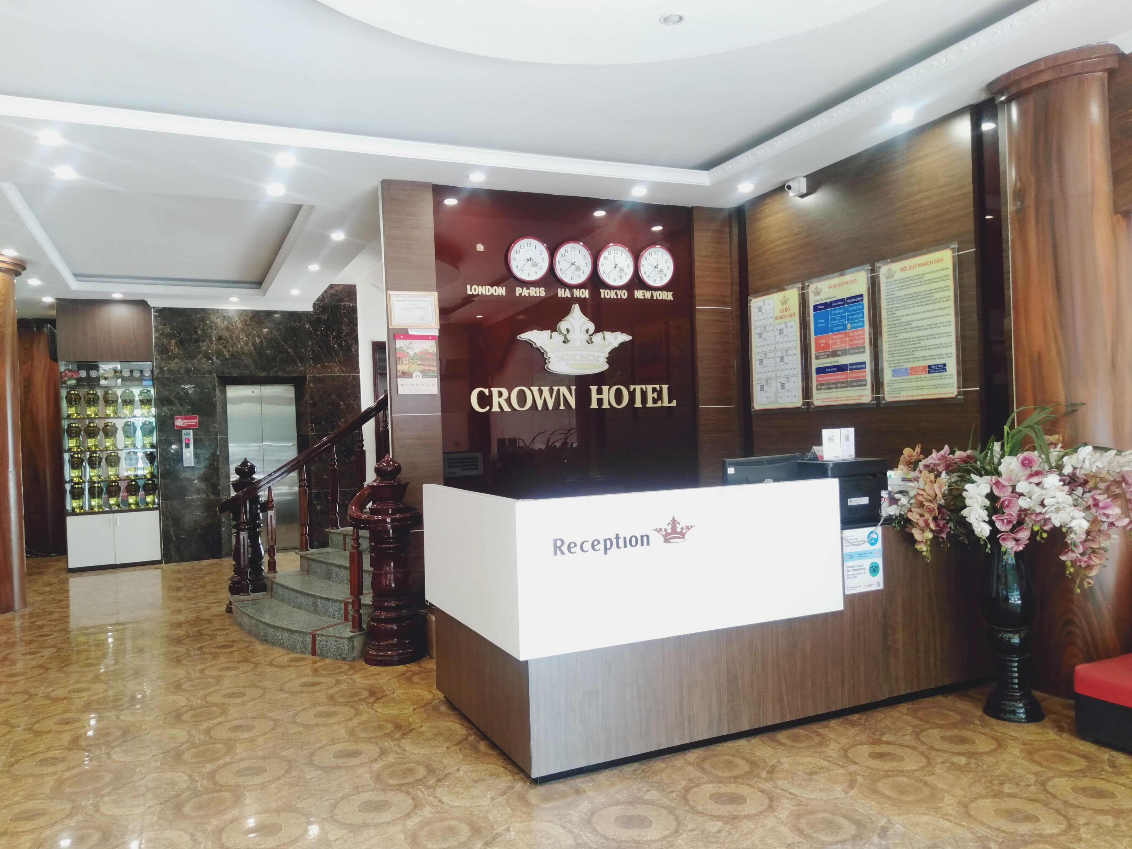 A reception desk at the Crown Hotel with a sign listing major cities.