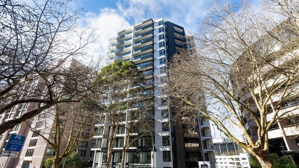 A multi-story building with a parking garage below.