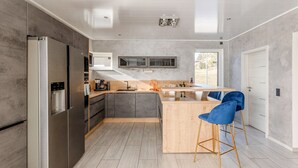 A modern kitchen with a large island, stainless steel appliances, and a minimalist design. - Modern Oasis w/ HotTub, View, Gym (Oberbettingen)