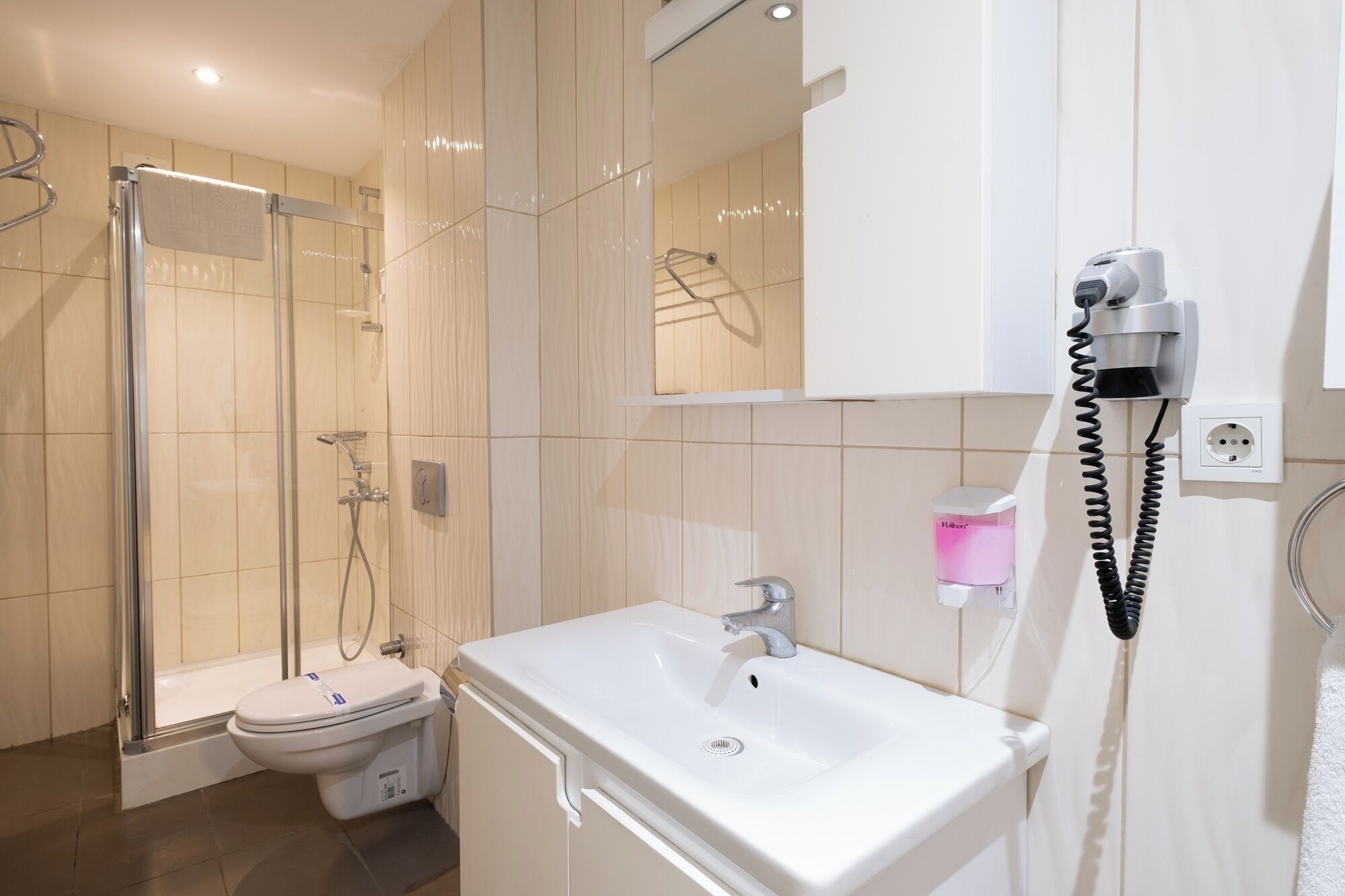 Une salle de bain moderne équipée d’une douche, de toilettes et d’un lavabo.