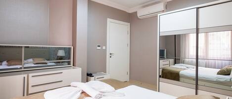 Une chambre d’hôtel équipée d’un lit, d’une table de chevet, d’un miroir, d’une armoire et d’un appareil de climatisation.