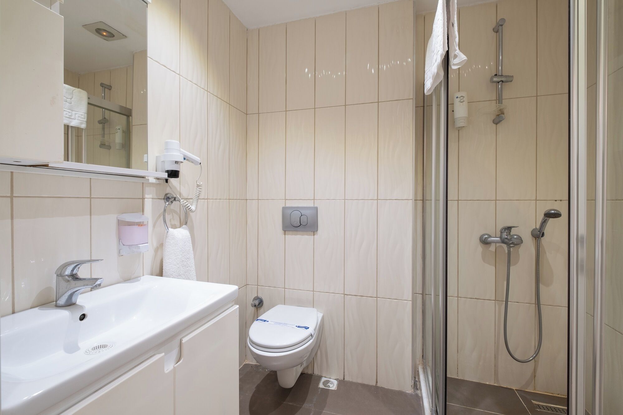 Un baño moderno con ducha, inodoro y lavamanos.