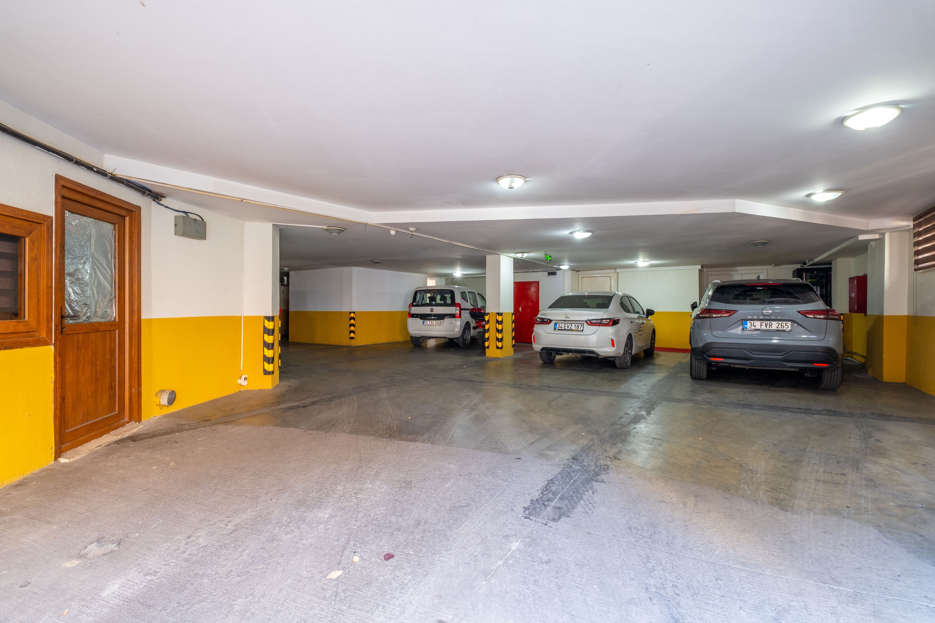 Garagem de estacionamento em vários níveis, com três carros estacionados.