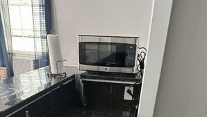 A modern kitchen with a stainless steel sink, a microwave, and a gas stove. - Roomy & Newly Renovated Guest House, Kitchen, Desk, Pet Friendly, Shared Patio! (Ellenwood)