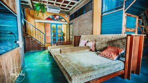 Una habitación con cama, una escalera y vistas al exterior.