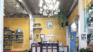 Un interior acogedor con un mostrador de recepción, suelo de baldosas y una araña de cristal.