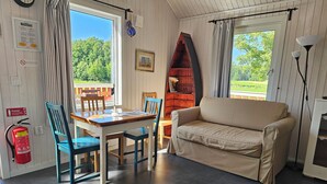 Una stanza accogliente con un tavolo in legno, sedie blu, un divano beige e un tappeto decorato.