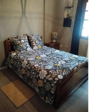 Cozy retreat with a floral-patterned bedspread and a comfortable bed.