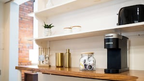 A kitchen shelf with a coffee maker, jars, and decorative items. - 30-Night Minimum South Main Apartment (Saint Charles)