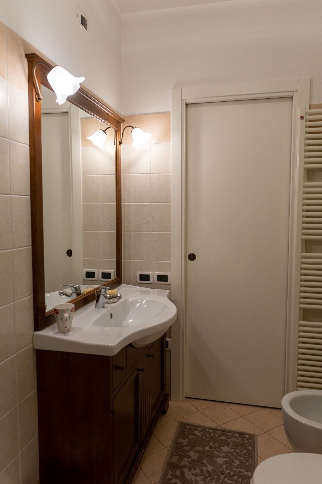 A bathroom with a white sink, a mirror, and a toilet.