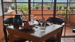 Een eettafel gedekt met borden, glazen en bestek, omringd door stoelen.
