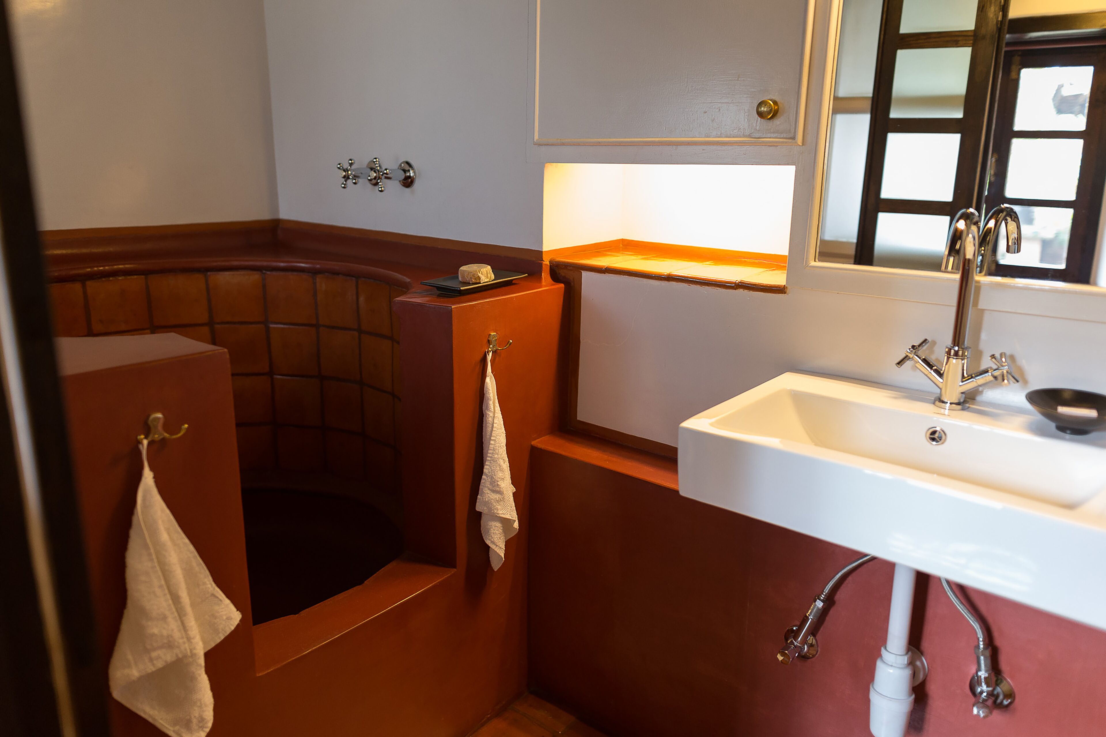 A bathroom with a bathtub, a sink, and a mirror.