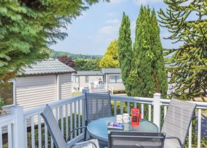 A deck with a table, chairs, and a red coffee maker. - 2 bedroom accommodation in Axminster (Axminster)