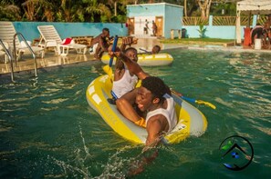 A pool area with inflatable rafts and lounge chairs.