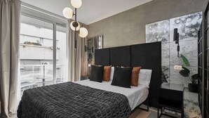 Une chambre à coucher moderne, dotée d’un grand lit, d’une tête de lit et offrant une vue sur la ville grâce à de grandes fenêtres.