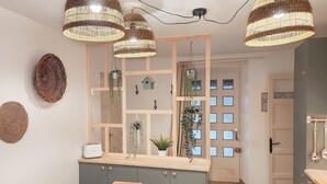 Une cuisine moderne dotée d’un îlot central intégré, de luminaires suspendus et donnant sur la salle à manger.