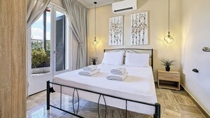A bedroom with a bed, two bedside tables, a window with curtains, and artwork on the wall. - Katerina's Place (ARGOS)