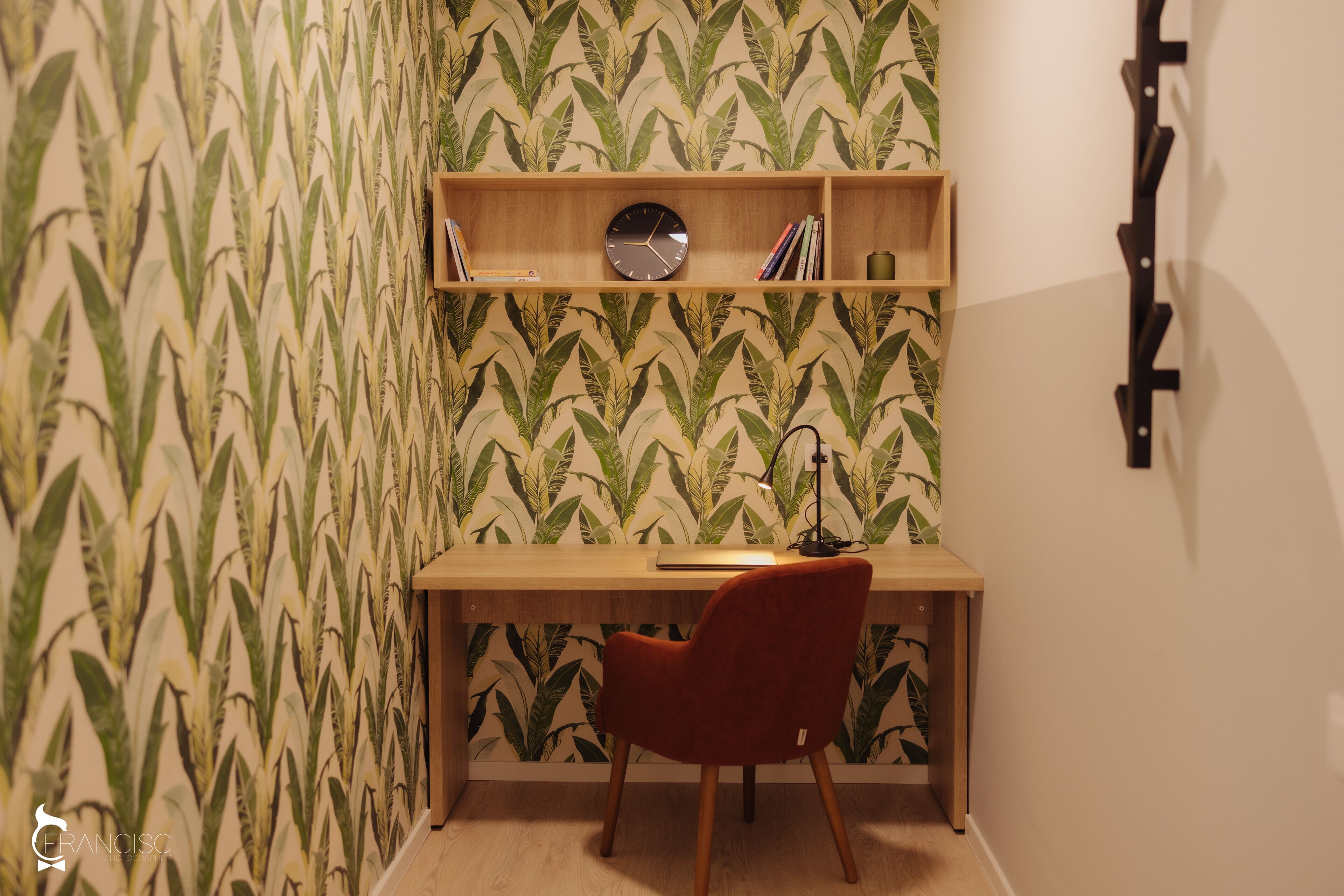A corner room with a desk, chair, and a wall clock.