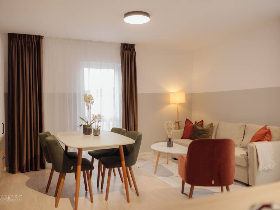 A modern living room with a dining table, chairs, a sofa, and a lamp.