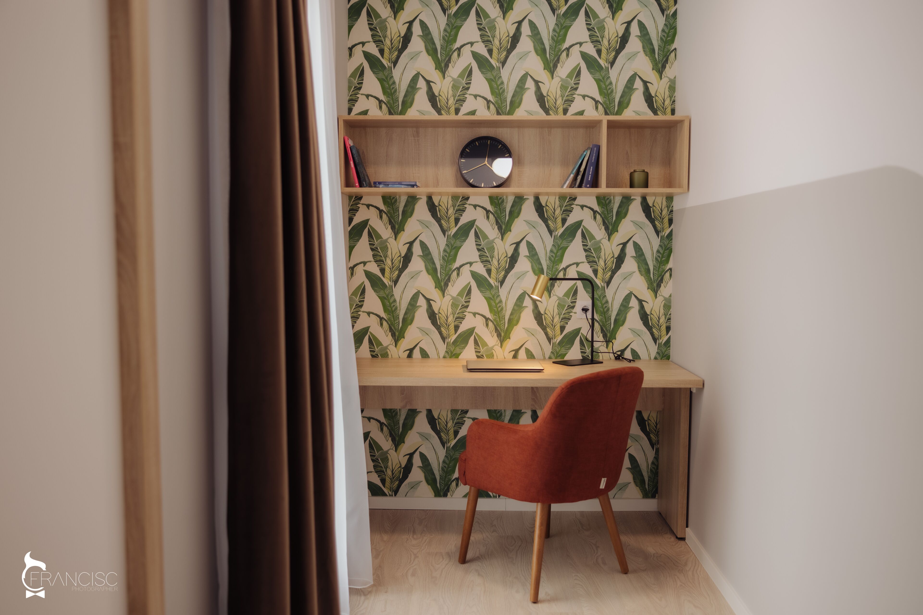 A study area with a desk, chair, shelves, and a clock.