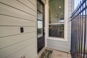A house entrance with a black door, a window with blinds, and a metal gate. - Meticulously-maintained 3-BR Home w/ Backyard - Double Story (Booth)