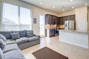 A modern kitchen with dark wood cabinets, stainless steel appliances, and a central island.