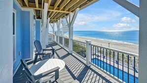 Ein überdachter Deckbereich mit Pool mit Blick auf einen Strand.