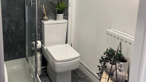 A bathroom with a glass shower enclosure, a toilet, and a radiator. - Casa Lobo's Beautiful Suites +free offroad parking (Wolverhampton)