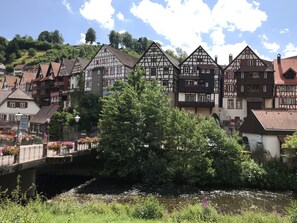 En traditionel europæisk by med bindingsværkshuse, en bro og en flod.