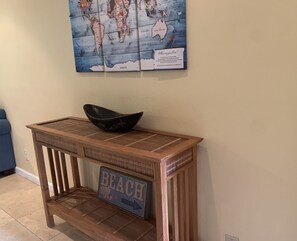 Ein hölzerner Konsolentisch mit einer Schale darauf und einem Schild mit der Aufschrift 'BEACH'.