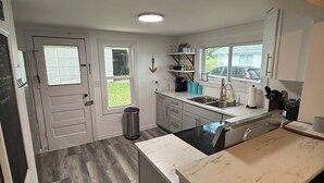 A modern kitchen with a marble countertop, a sink, and a trash can. - 3 BR Lakefront house, sandy bottom on Lake Dewey in the Sister Lakes (Dowagiac)