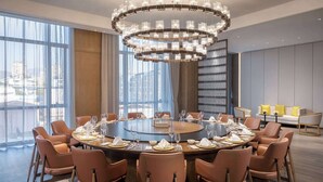 A modern dining room with a round table set for a meal, surrounded by leather chairs. - Wyndham Grand Lishui Downtown (Lishui)