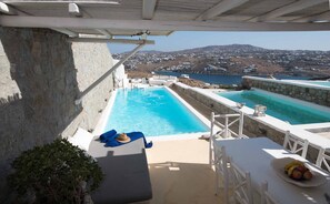 A rooftop pool with a view of a coastal town and a mountain in the background. - White Stone Mykonos Hotel (Mykonos)