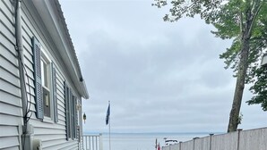Ein Wohnhaus mit befestigter Auffahrt, die zu einem Steg über dem Wasser führt.