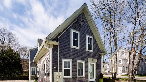 A two-story house with a gabled roof, a garage, and a front porch.