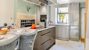 Una cocina moderna con una isla central, electrodomésticos integrados y vistas de la ciudad a través de un ventanal.