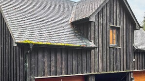 A wooden building with a sloped roof and a garage door. - This studio apartment is brilliant. (West Linton, near Edinburgh)