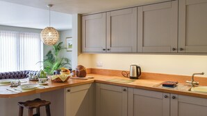 A kitchen with a wooden countertop, a kettle, a sink, and a bar stool. - 1 bedroom accommodation in Strumpshaw, near Norwich (Strumpshaw, near Norwich)