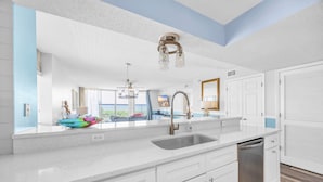 A kitchen with white cabinets, a stainless steel sink, and a dishwasher.