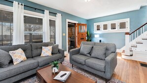 A living room with two grey sofas, a wooden coffee table, and a patterned rug. - 3 Bed 2 Bath by College Hill w/ Fitness Room (Wichita)