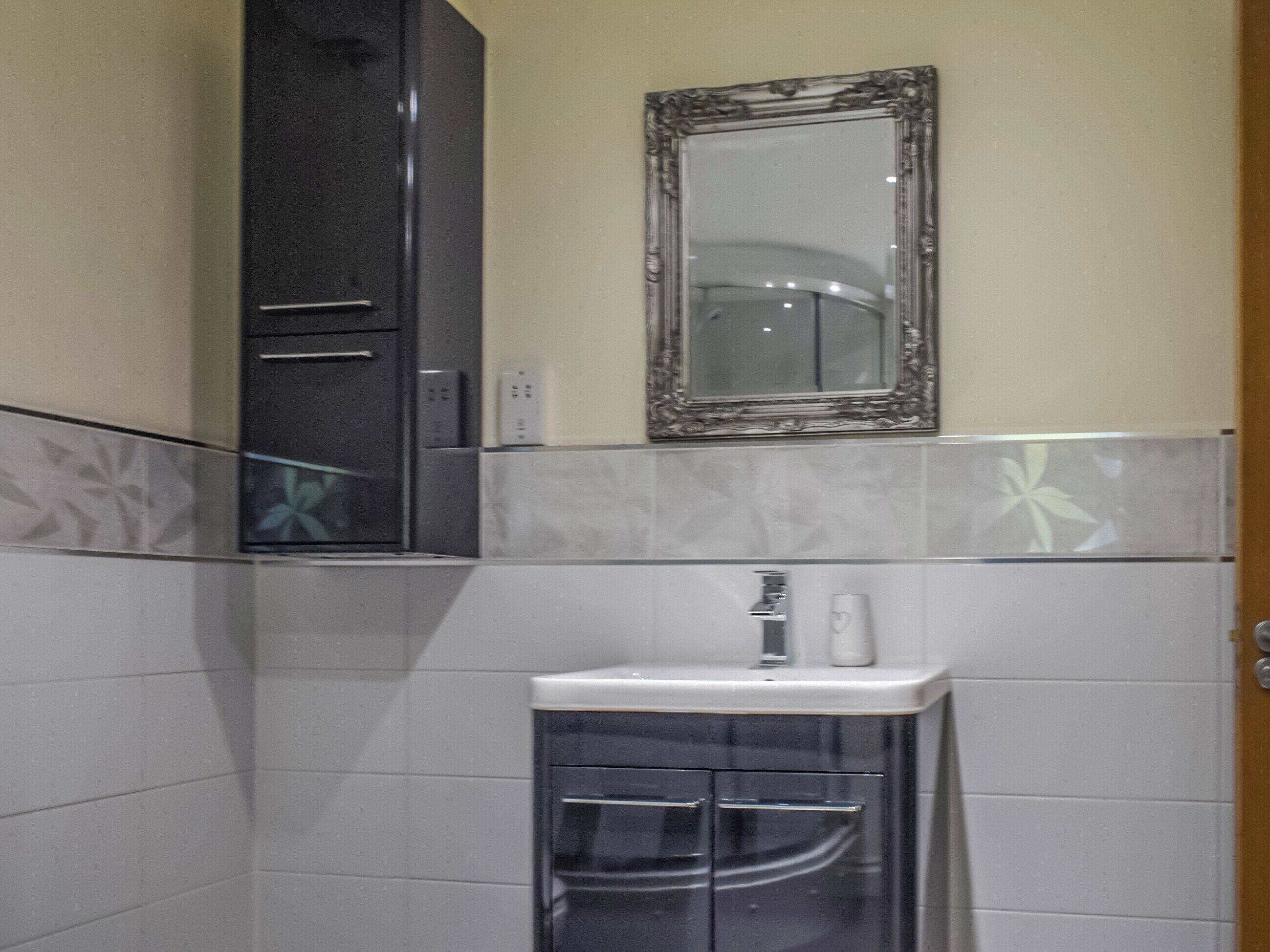 A bathroom with a sink, mirror, and cabinets.
