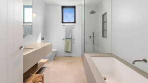 A modern bathroom with a large bathtub, a glass-enclosed shower, a toilet, and a vanity with a mirror. - Gorgeous George Barwon Heads (Barwon Heads)
