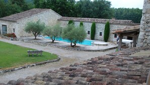 A stone building with a swimming pool, a bench, and a pergola. - Gite DE Bellecombe AU Chateau Plaisir de la Campagne Proche des Parcs de Loisirs (Puymirol)