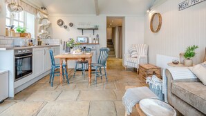 A cozy kitchen with a dining area, a staircase, and a living room with a sofa and a side table. - 2 bedroom accommodation in Walsingham, Wells-next-the-Sea (Walsingham, Wells-next-the-Sea)